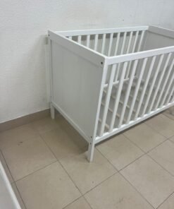 The white IKEA SUNDVIK crib (60x120 cm) features a sturdy wooden design and a bed base that can be adjusted to two different heights. - Image 12