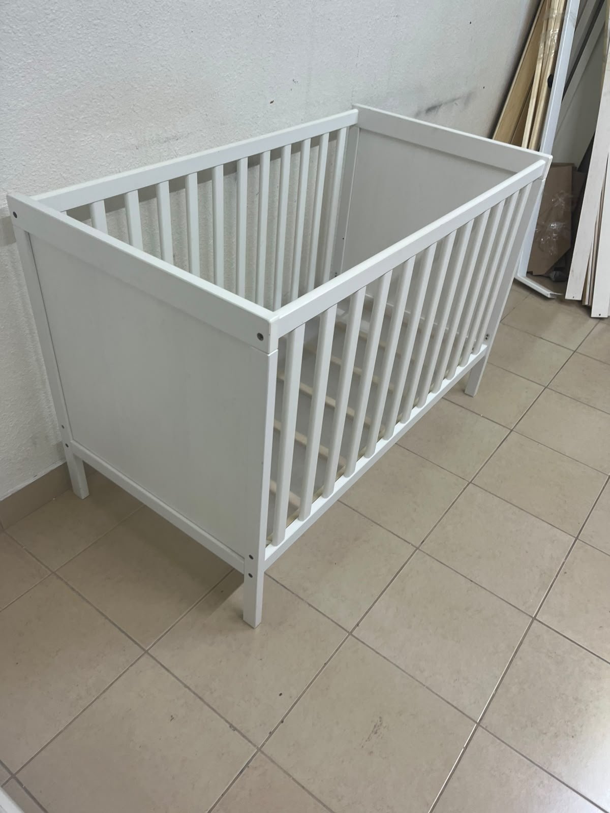 The white IKEA SUNDVIK crib (60x120 cm) features a sturdy wooden design and a bed base that can be adjusted to two different heights. - Image 14