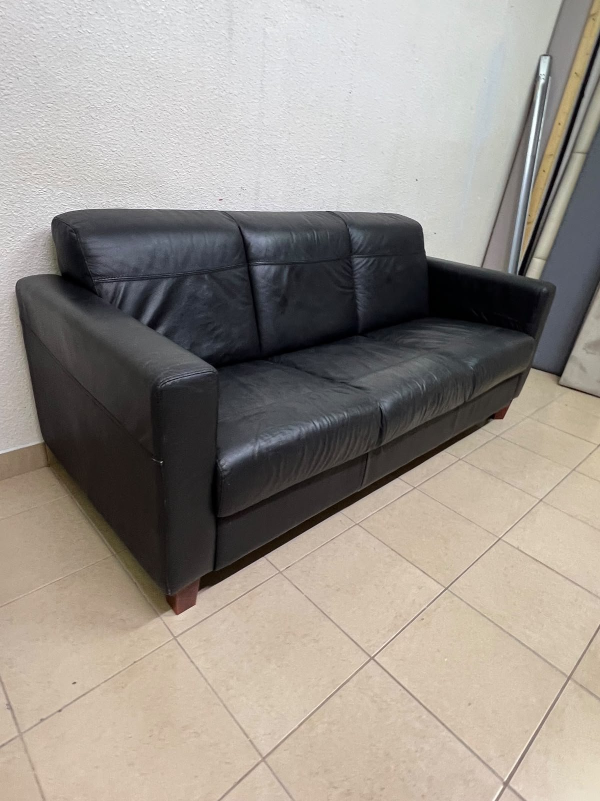 A modern three-seater black leather sofa featuring square armrests and wooden legs, resembling the IKEA "Skogaby" model. - Image 2