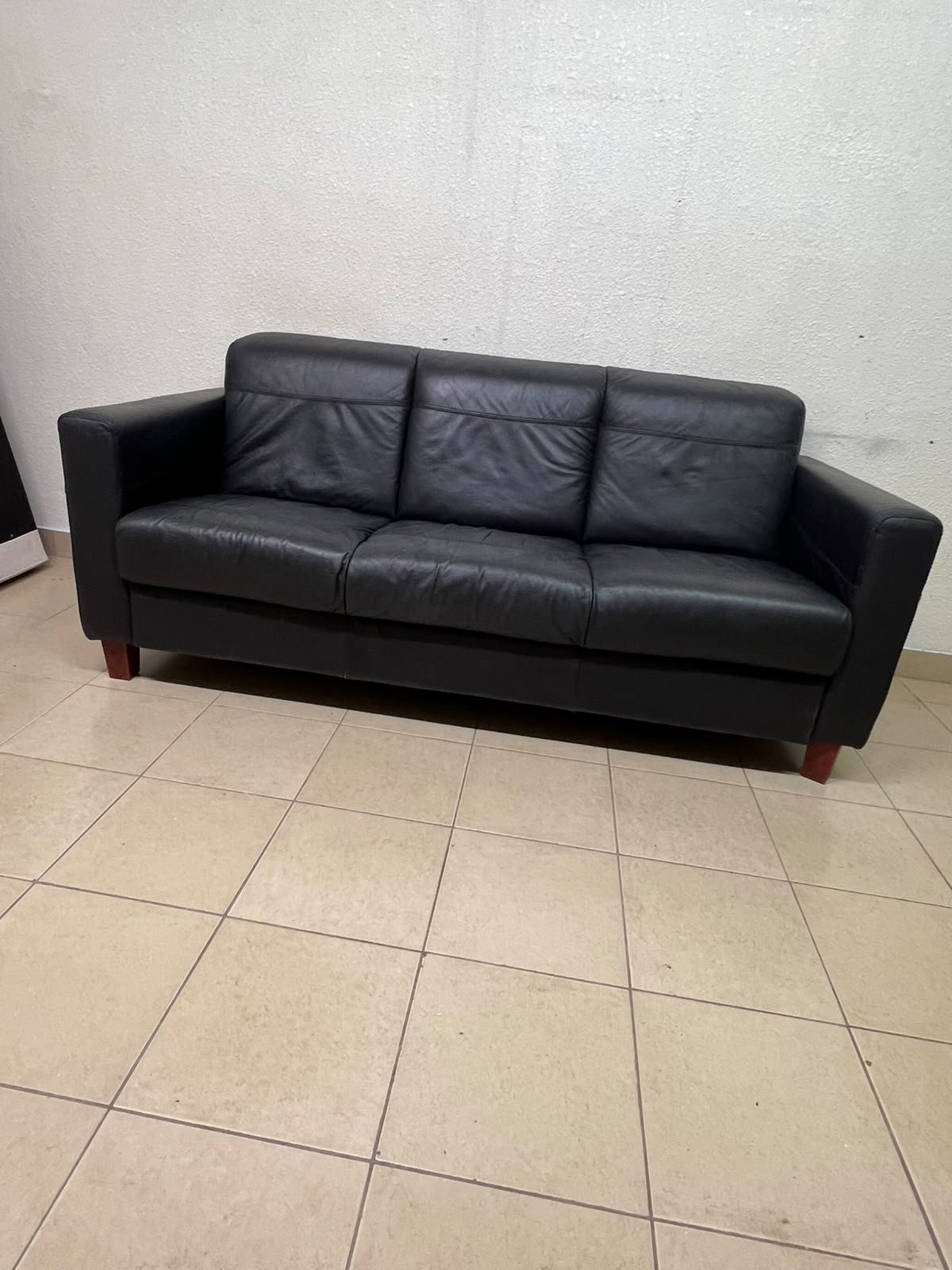 A modern three-seater black leather sofa featuring square armrests and wooden legs, resembling the IKEA "Skogaby" model. - Image 3