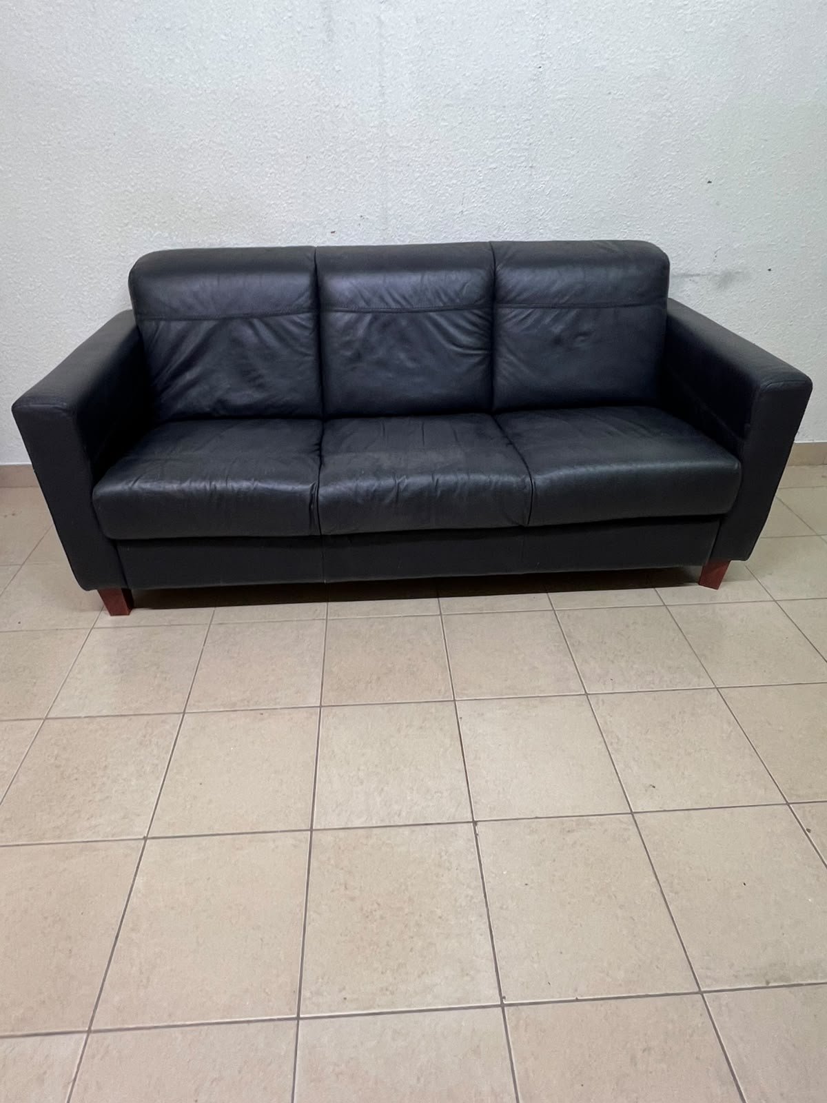 A modern three-seater black leather sofa featuring square armrests and wooden legs, resembling the IKEA "Skogaby" model. - Image 4