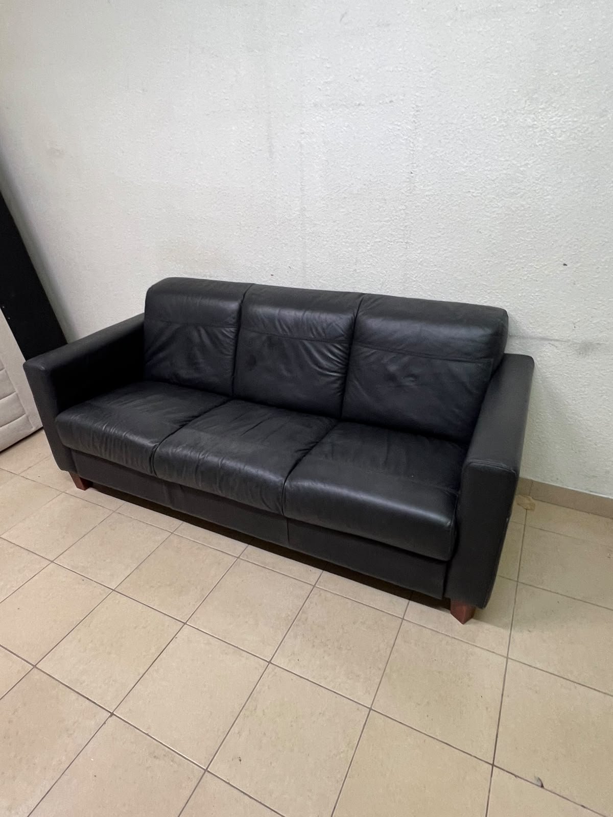 A modern three-seater black leather sofa featuring square armrests and wooden legs, resembling the IKEA "Skogaby" model. - Image 7