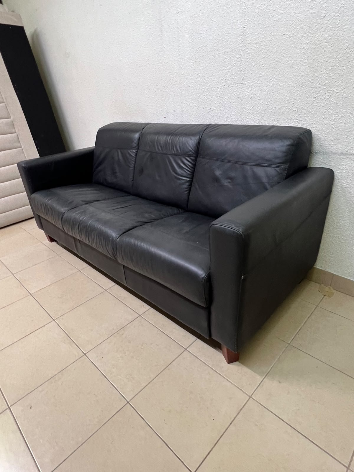 A modern three-seater black leather sofa featuring square armrests and wooden legs, resembling the IKEA "Skogaby" model. - Image 8
