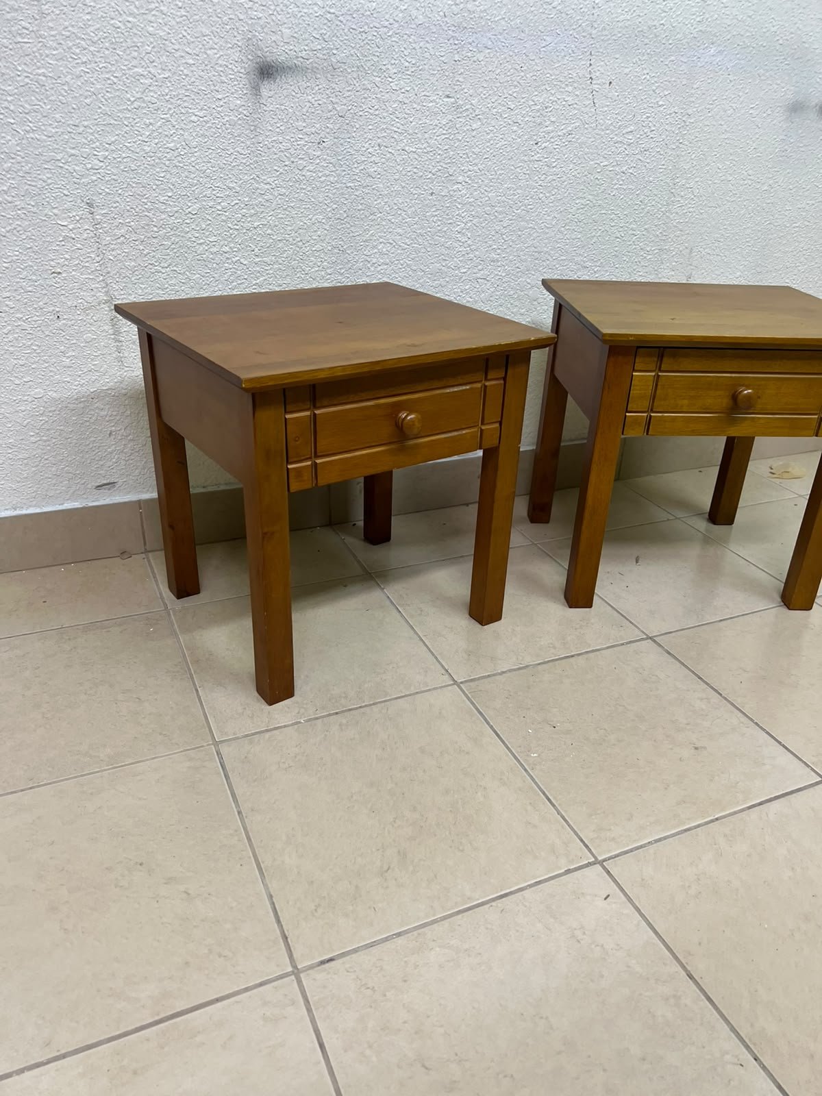 Two classic, medium-toned wooden side tables featuring a single drawer with a round wooden knob and classic grooved detailing on the frame. - Image 3