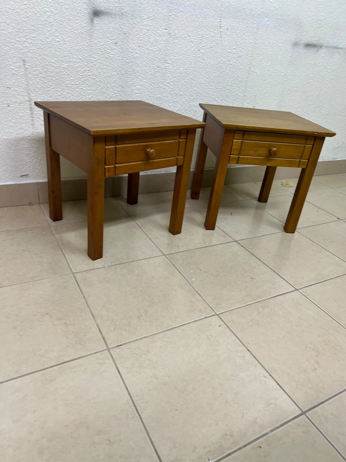 Two classic, medium-toned wooden side tables featuring a single drawer with a round wooden knob and classic grooved detailing on the frame. - Image 7