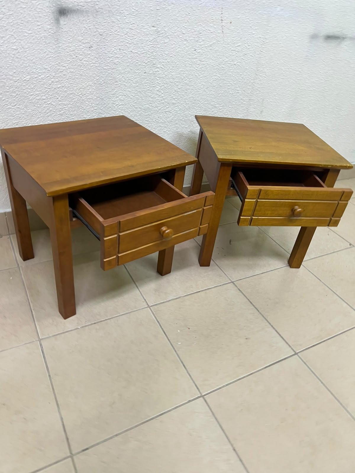 Two classic, medium-toned wooden side tables featuring a single drawer with a round wooden knob and classic grooved detailing on the frame. - Image 9
