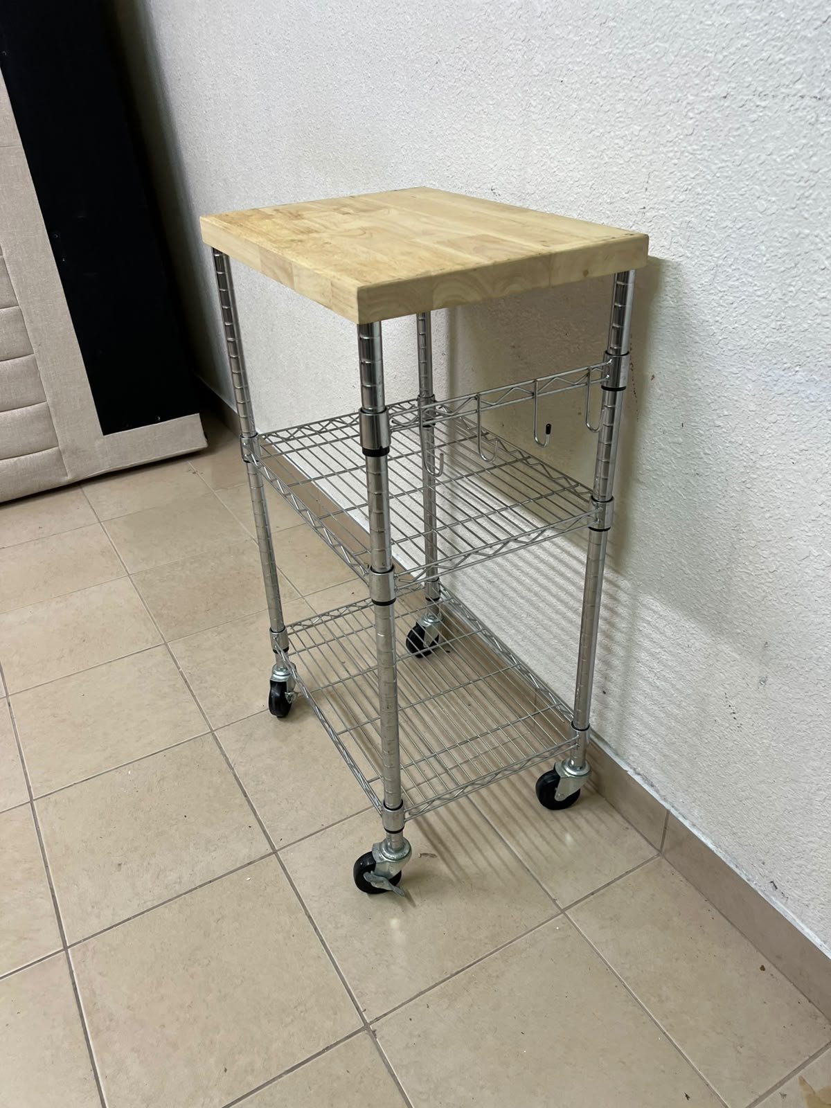 A multi-shelf kitchen cart made of chrome wire, featuring a light-colored wood top (butcher block style) and swivel casters. - Image 5
