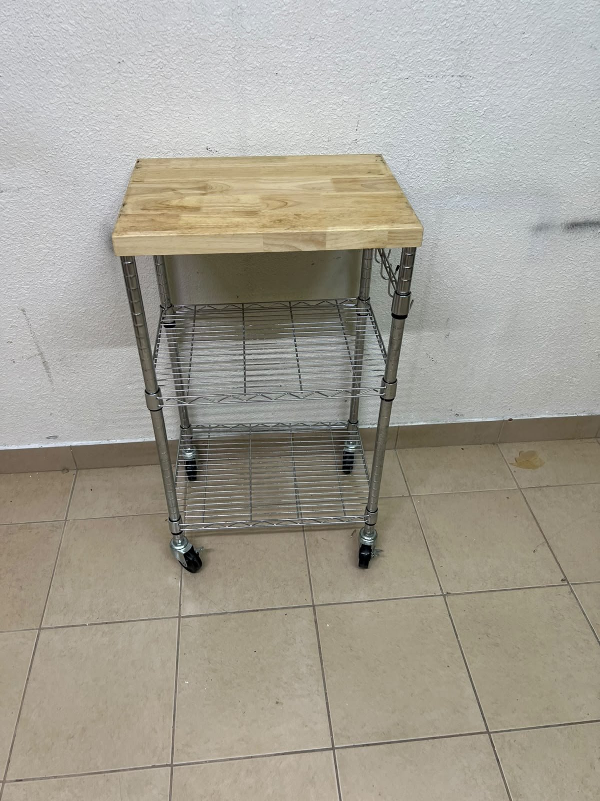 A multi-shelf kitchen cart made of chrome wire, featuring a light-colored wood top (butcher block style) and swivel casters. - Image 6