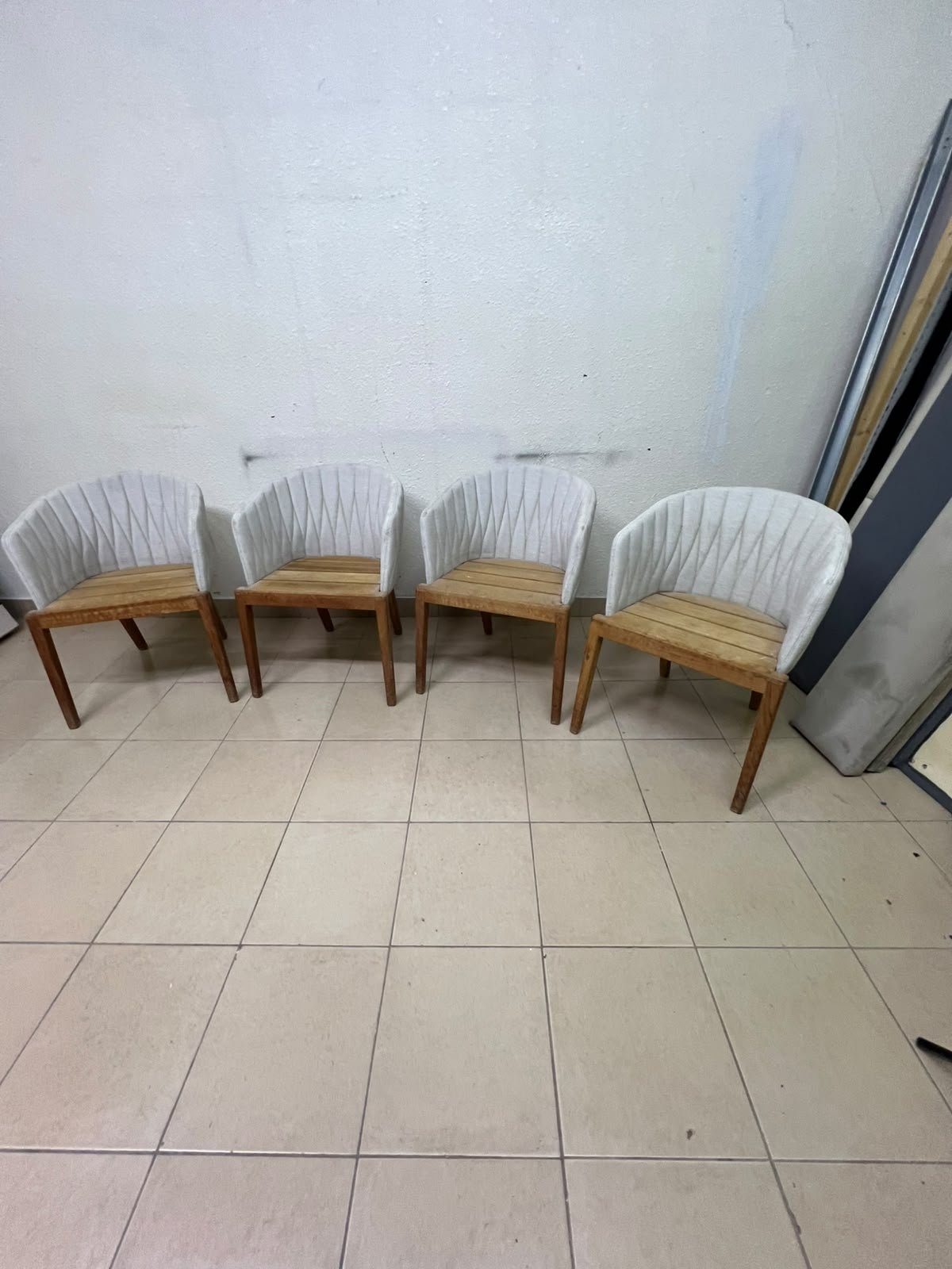 The "Calypso" garden chair by Royal Botania, featuring a solid teak base and an upholstered backrest with a unique design incorporating vertical stitching.