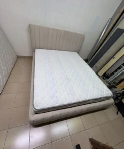 A bed featuring a modern design and a beige upholstered frame, complete with a headboard designed with padded vertical channels and a matching upholstered base; its style resembles the "Curvy Haze" upholstered bed available at Home Box. - Image 8