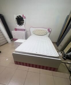 A girls' bedroom featuring a white and pink color scheme, including a bed with bedding, a storage table with an illuminated mirror, and a bedside table. - Image 12