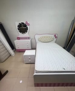 A girls' bedroom featuring a white and pink color scheme, including a bed with bedding, a storage table with an illuminated mirror, and a bedside table. - Image 2