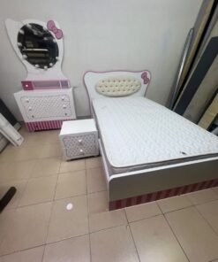 A girls' bedroom featuring a white and pink color scheme, including a bed with bedding, a storage table with an illuminated mirror, and a bedside table. - Image 3