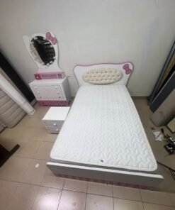 A girls' bedroom featuring a white and pink color scheme, including a bed with bedding, a storage table with an illuminated mirror, and a bedside table. - Image 4