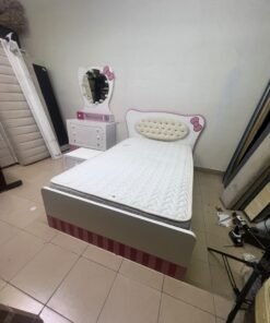 A girls' bedroom featuring a white and pink color scheme, including a bed with bedding, a storage table with an illuminated mirror, and a bedside table. - Image 5