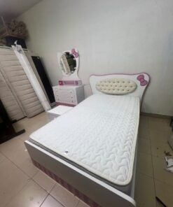 A girls' bedroom featuring a white and pink color scheme, including a bed with bedding, a storage table with an illuminated mirror, and a bedside table. - Image 7