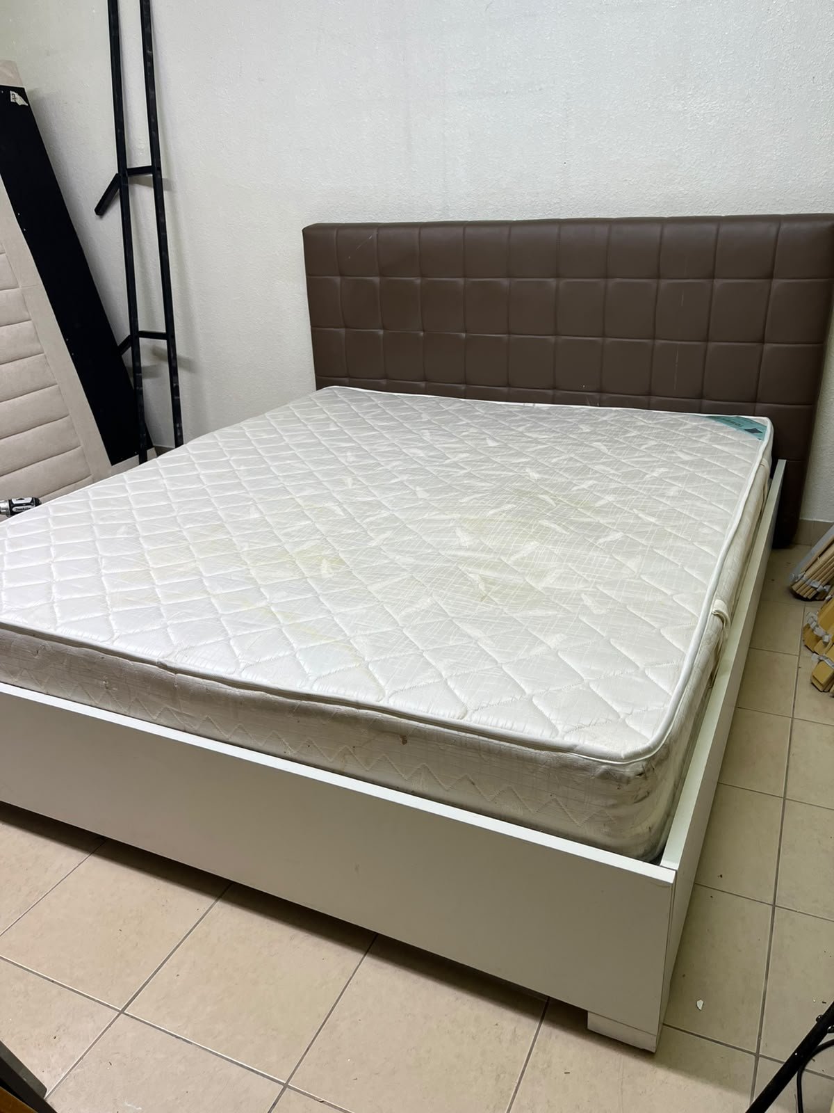 A modern white wooden king-size bed, paired with a cushioned spring mattress and a brown faux-leather upholstered headboard. - Image 9