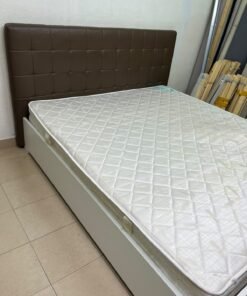 A modern white wooden king-size bed, paired with a cushioned spring mattress and a brown faux-leather upholstered headboard.