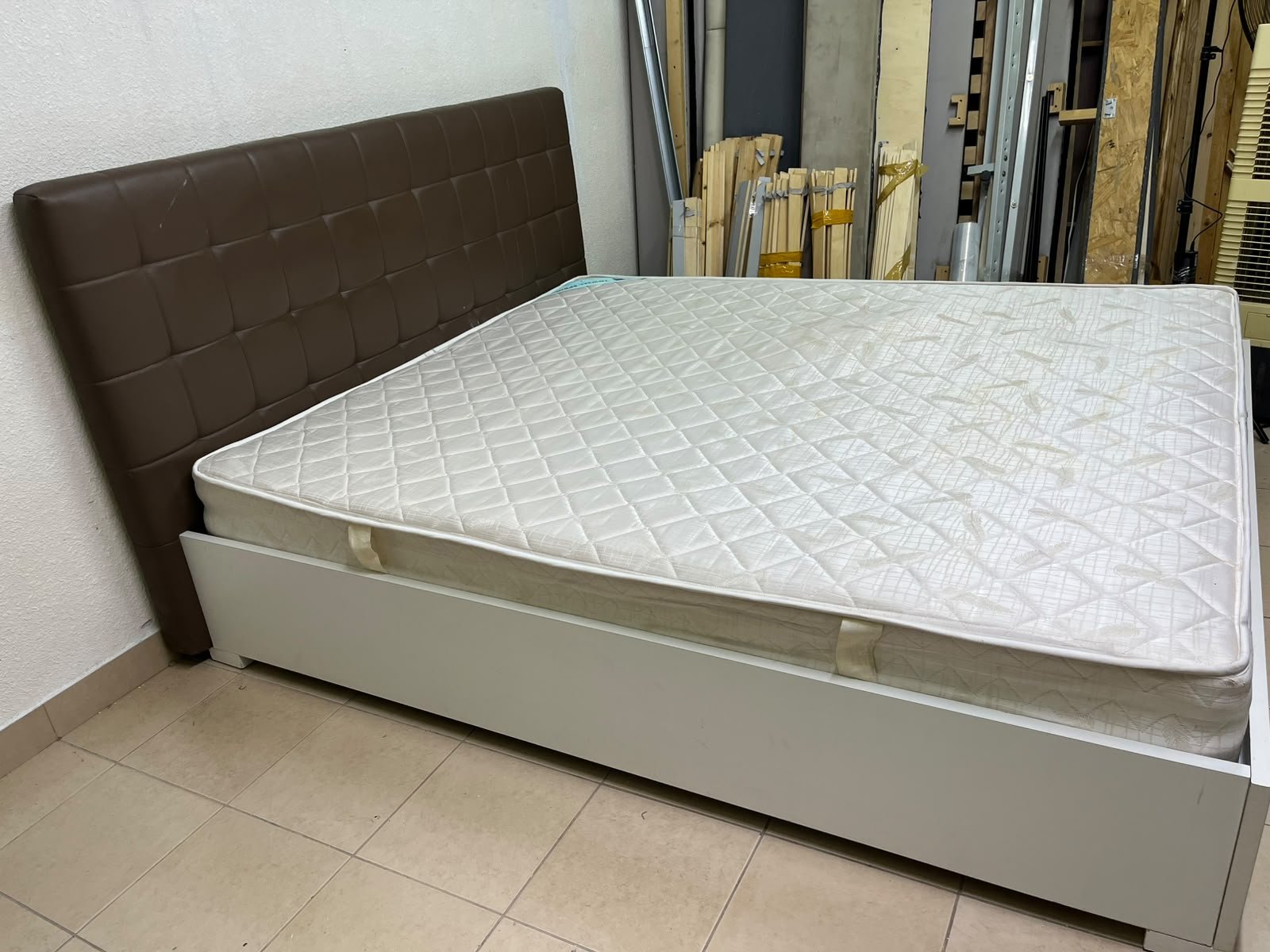 A modern white wooden king-size bed, paired with a cushioned spring mattress and a brown faux-leather upholstered headboard. - Image 3
