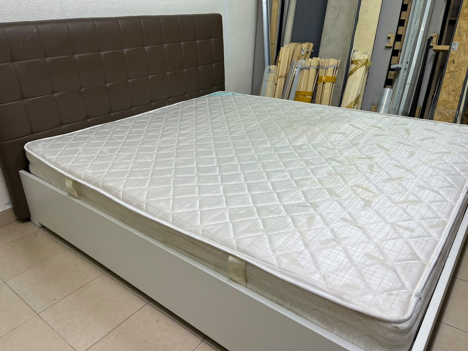 A modern white wooden king-size bed, paired with a cushioned spring mattress and a brown faux-leather upholstered headboard. - Image 5