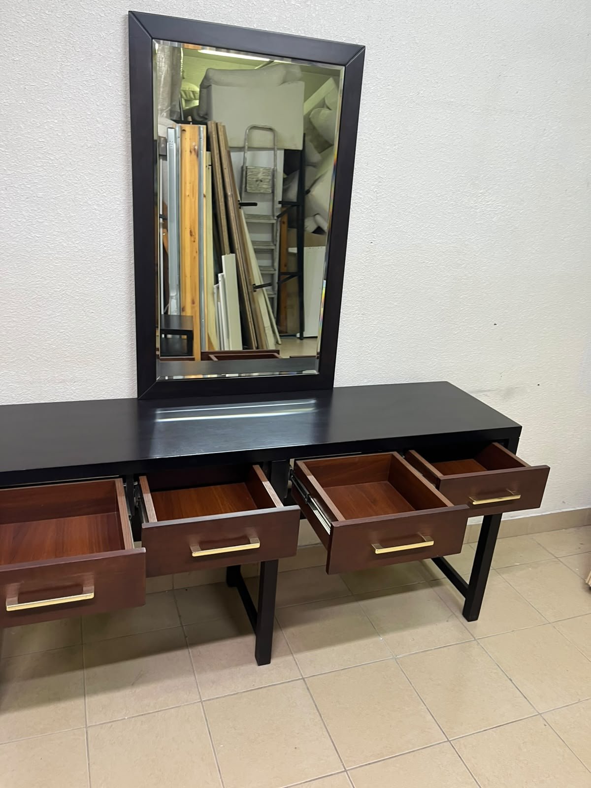 An ultra-long, modern console or vanity table featuring a black wooden frame, contrasting warm-toned wooden drawers, and gold-finished metal handles; it comes with a matching wall mirror. - Image 2