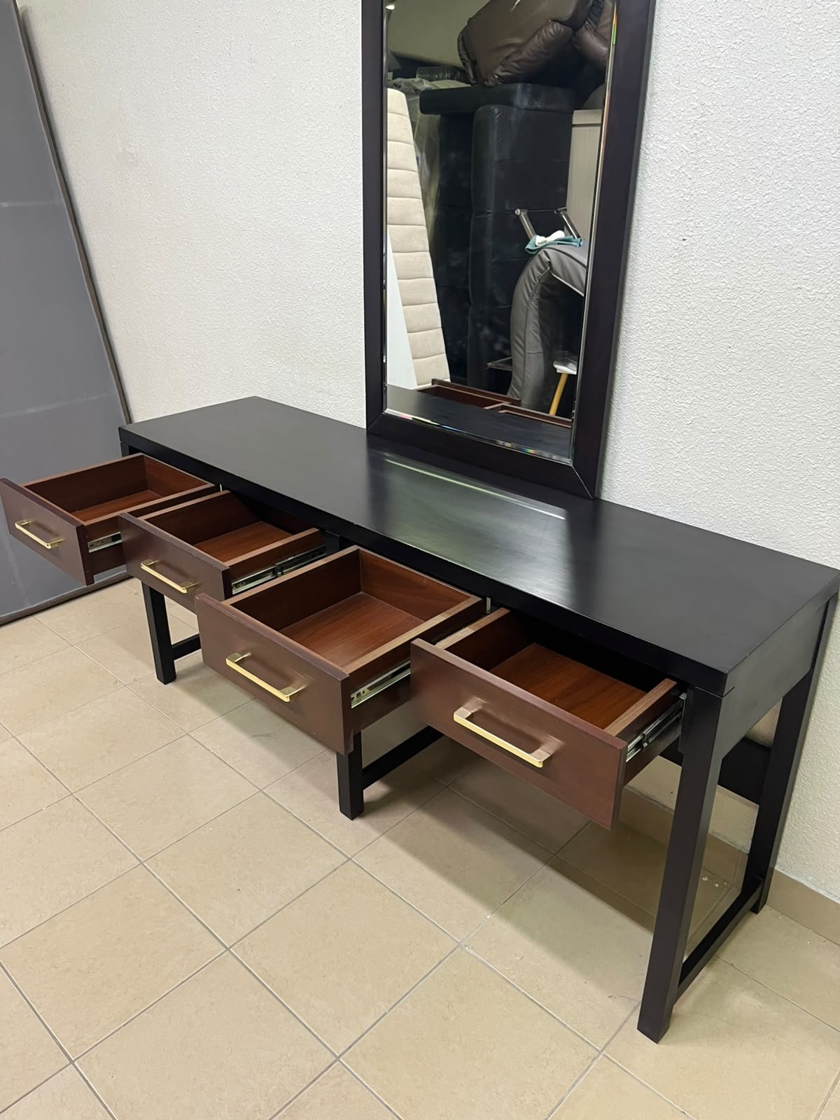An ultra-long, modern console or vanity table featuring a black wooden frame, contrasting warm-toned wooden drawers, and gold-finished metal handles; it comes with a matching wall mirror. - Image 4