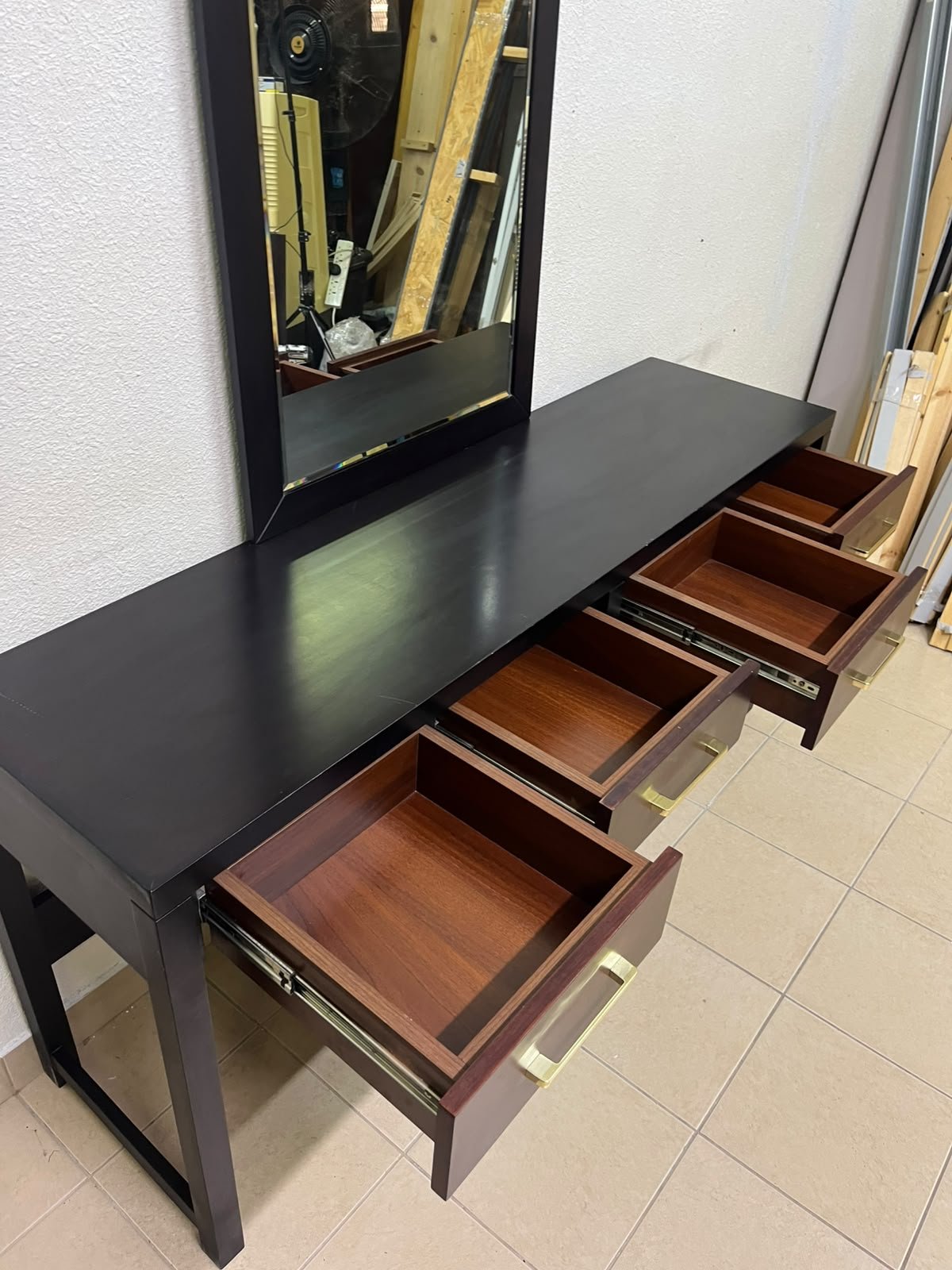 An ultra-long, modern console or vanity table featuring a black wooden frame, contrasting warm-toned wooden drawers, and gold-finished metal handles; it comes with a matching wall mirror. - Image 6
