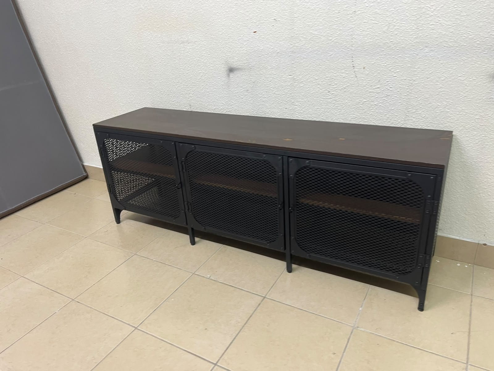The FJÄLLBO TV unit from IKEA, featuring an industrial design with a solid wood top and black metal mesh doors. - Image 2