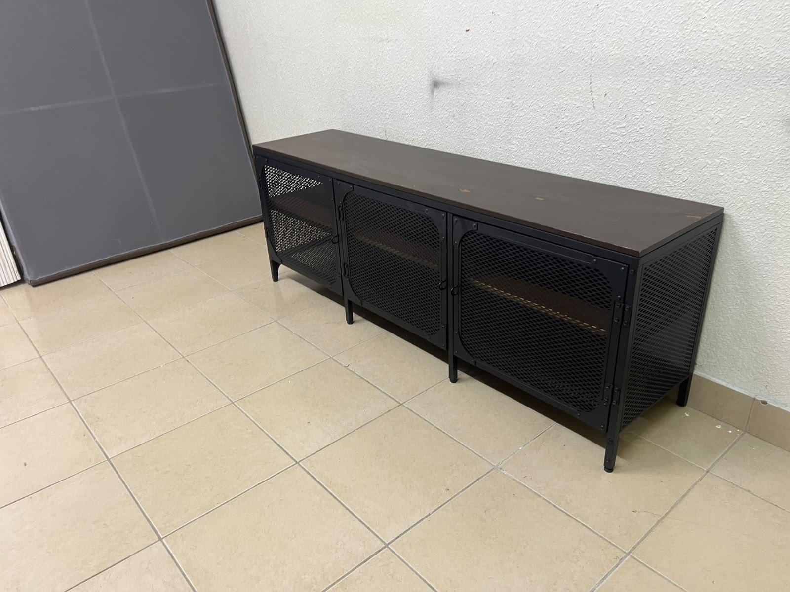 The FJÄLLBO TV unit from IKEA, featuring an industrial design with a solid wood top and black metal mesh doors. - Image 3