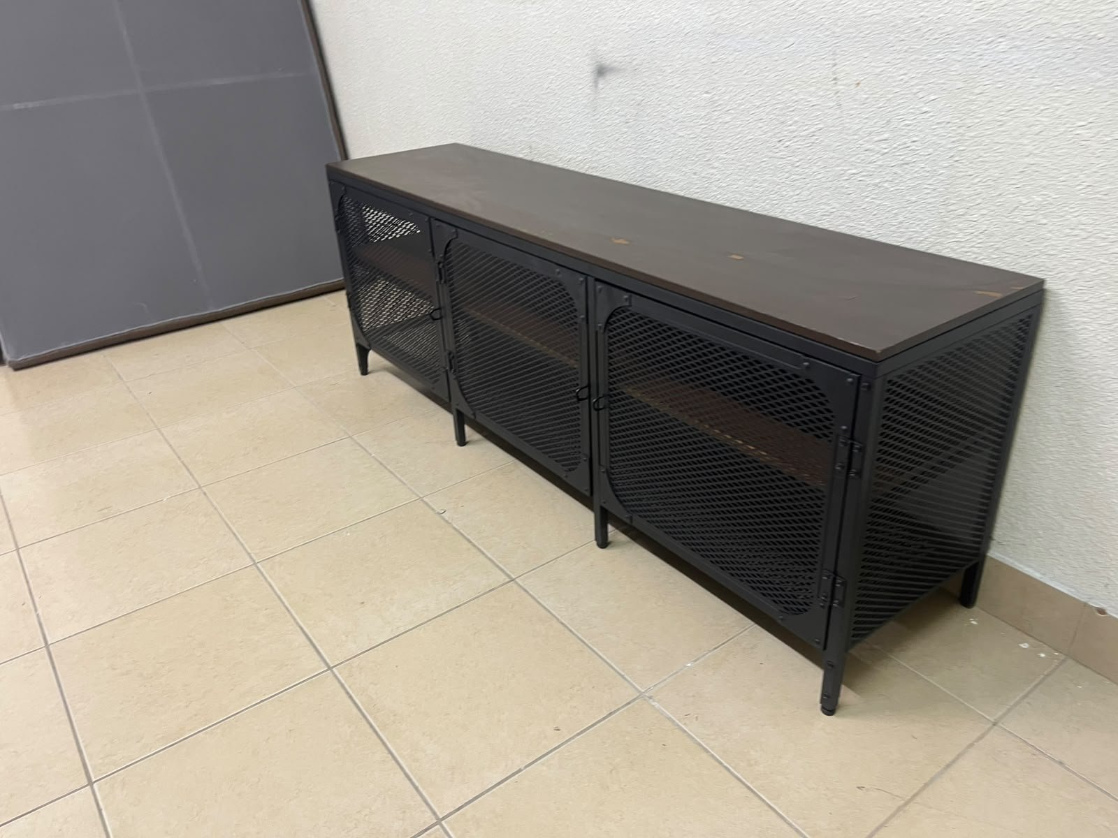 The FJÄLLBO TV unit from IKEA, featuring an industrial design with a solid wood top and black metal mesh doors. - Image 6
