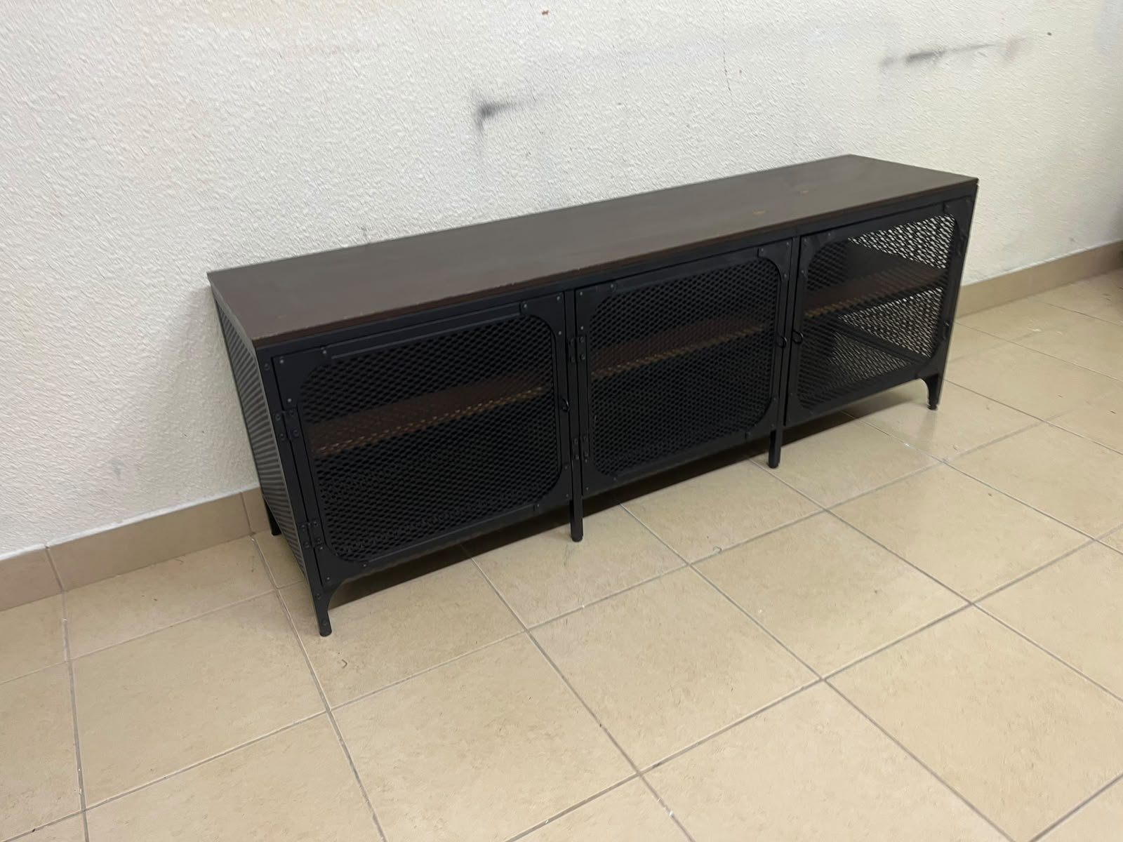 The FJÄLLBO TV unit from IKEA, featuring an industrial design with a solid wood top and black metal mesh doors. - Image 7
