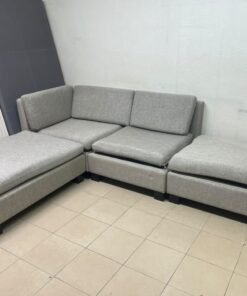 This appears to be a light gray fabric modular sofa, featuring matching ottomans and low, dark block-style legs. - Image 2