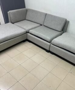 This appears to be a light gray fabric modular sofa, featuring matching ottomans and low, dark block-style legs. - Image 3