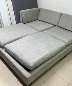 This appears to be a light gray fabric modular sofa, featuring matching ottomans and low, dark block-style legs. - Image 4