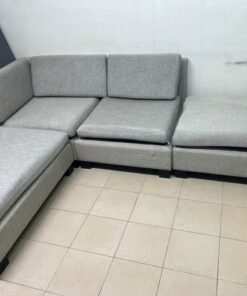 This appears to be a light gray fabric modular sofa, featuring matching ottomans and low, dark block-style legs. - Image 5