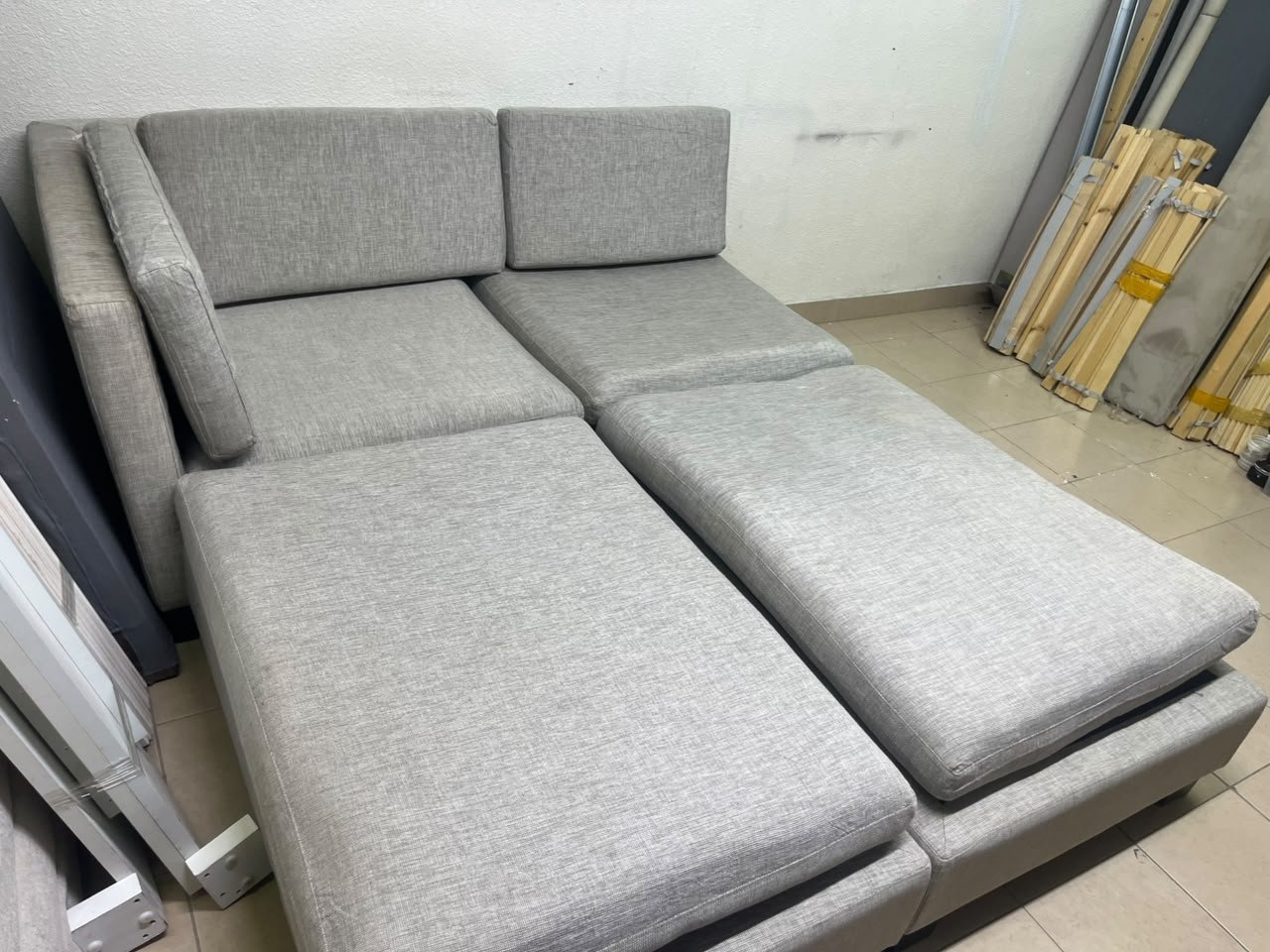 This appears to be a light gray fabric modular sofa, featuring matching ottomans and low, dark block-style legs. - Image 7