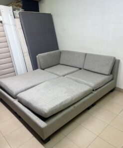 This appears to be a light gray fabric modular sofa, featuring matching ottomans and low, dark block-style legs. - Image 9