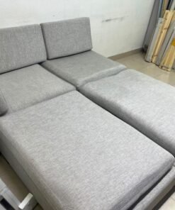 This appears to be a light gray fabric modular sofa, featuring matching ottomans and low, dark block-style legs. - Image 10