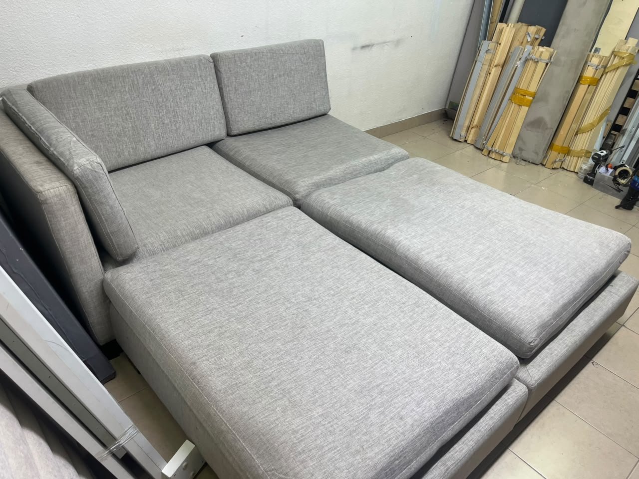 This appears to be a light gray fabric modular sofa, featuring matching ottomans and low, dark block-style legs. - Image 10