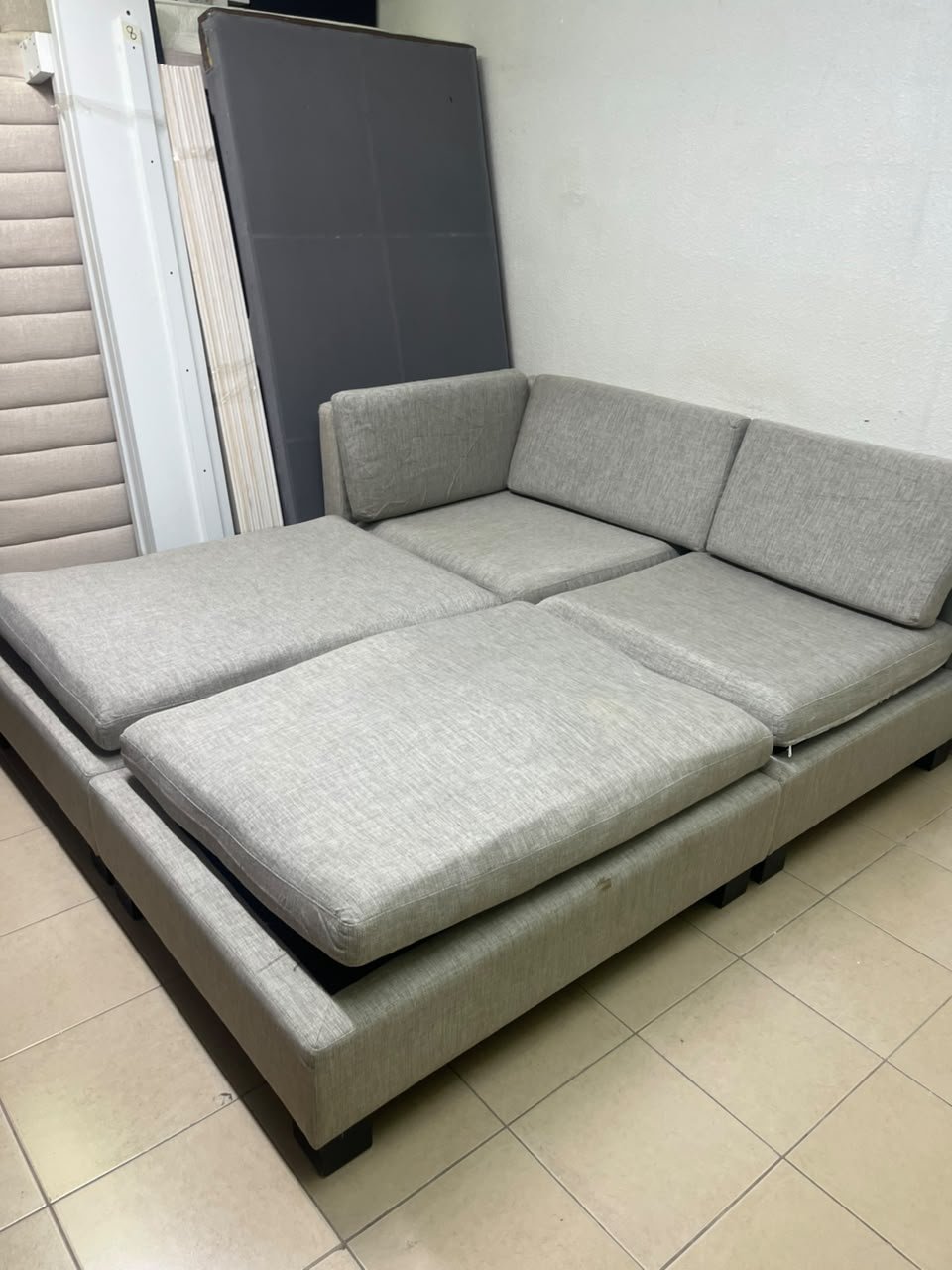 This appears to be a light gray fabric modular sofa, featuring matching ottomans and low, dark block-style legs. - Image 11