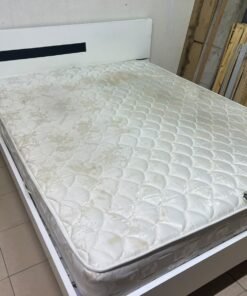 A white wooden bed frame paired with an "Intercoil Deluxe" sprung, cushioned mattress.