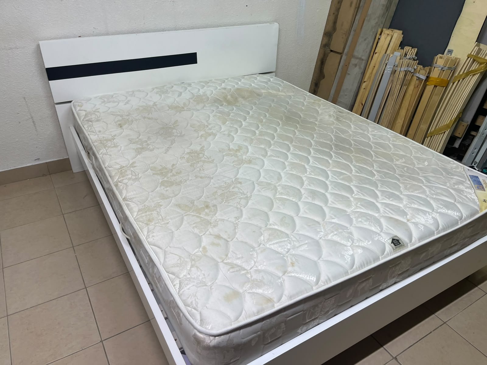 A white wooden bed frame paired with an "Intercoil Deluxe" sprung, cushioned mattress.