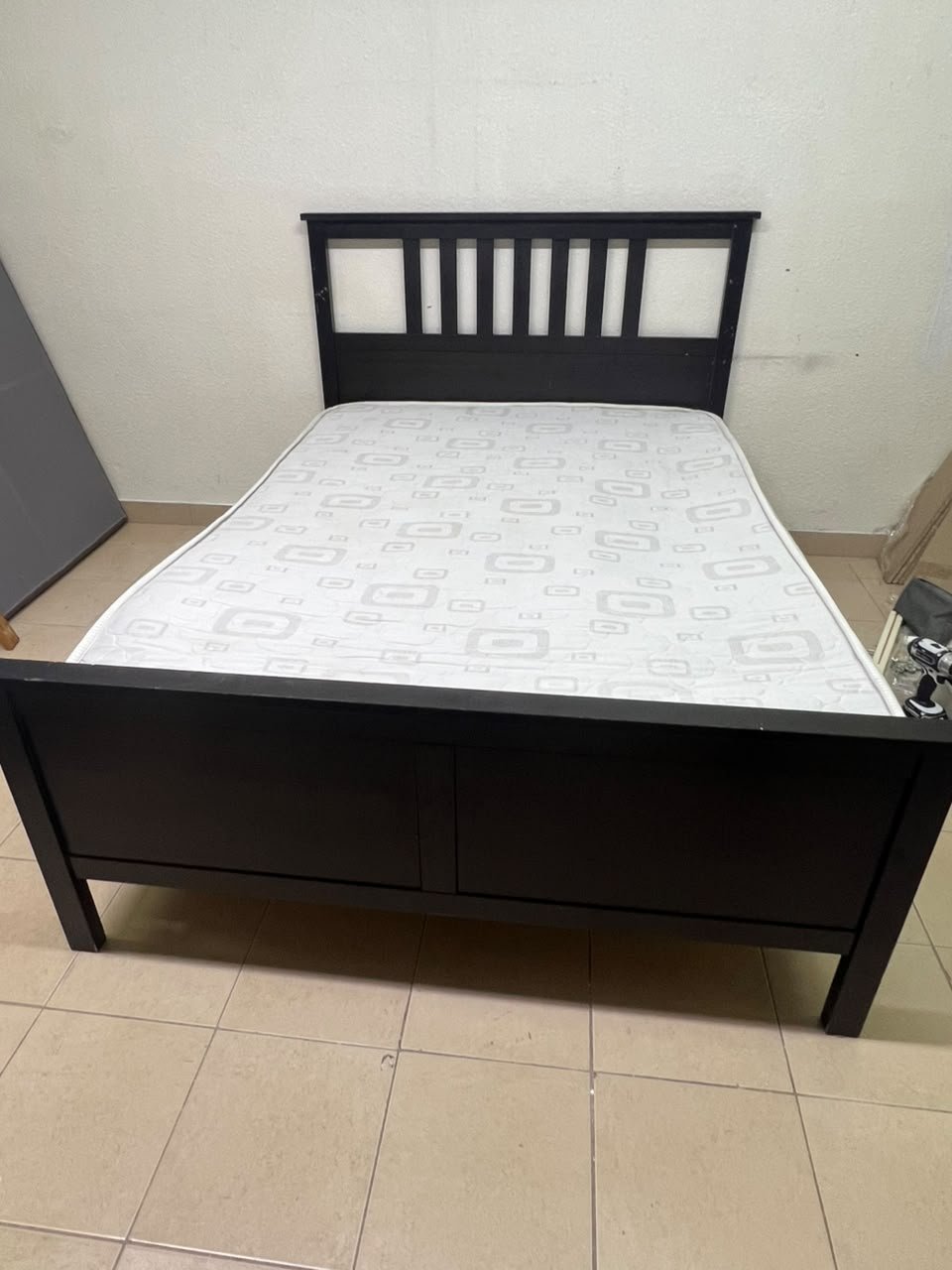 An IKEA "HEMNES" wooden bed frame in a black-brown finish, featuring a slatted headboard and a matching mattress. - Image 2