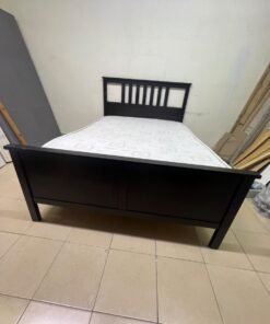 An IKEA "HEMNES" wooden bed frame in a black-brown finish, featuring a slatted headboard and a matching mattress. - Image 3