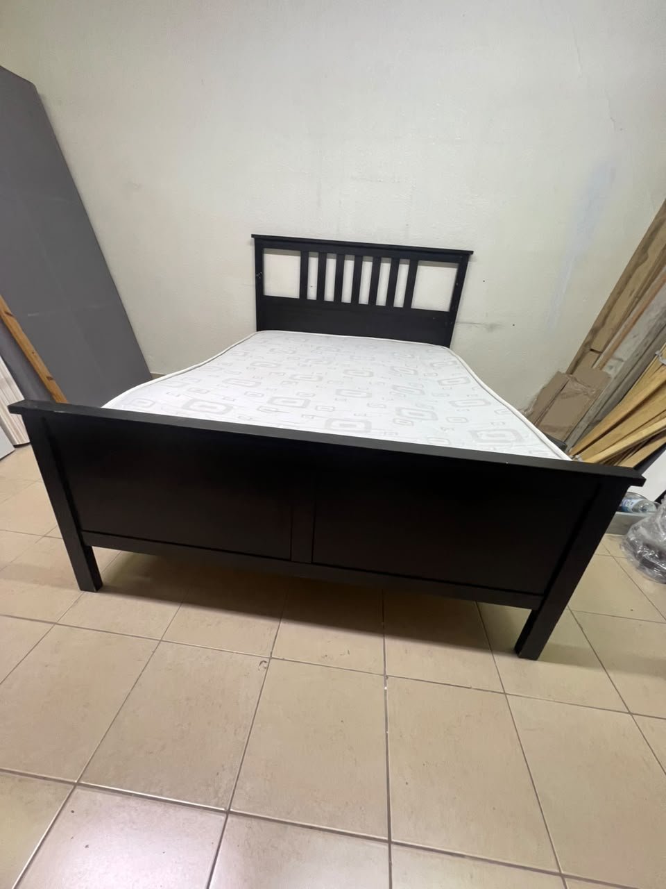 An IKEA "HEMNES" wooden bed frame in a black-brown finish, featuring a slatted headboard and a matching mattress. - Image 3