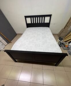 An IKEA "HEMNES" wooden bed frame in a black-brown finish, featuring a slatted headboard and a matching mattress. - Image 5