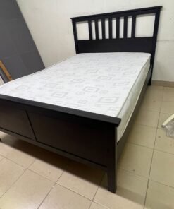 An IKEA "HEMNES" wooden bed frame in a black-brown finish, featuring a slatted headboard and a matching mattress. - Image 7
