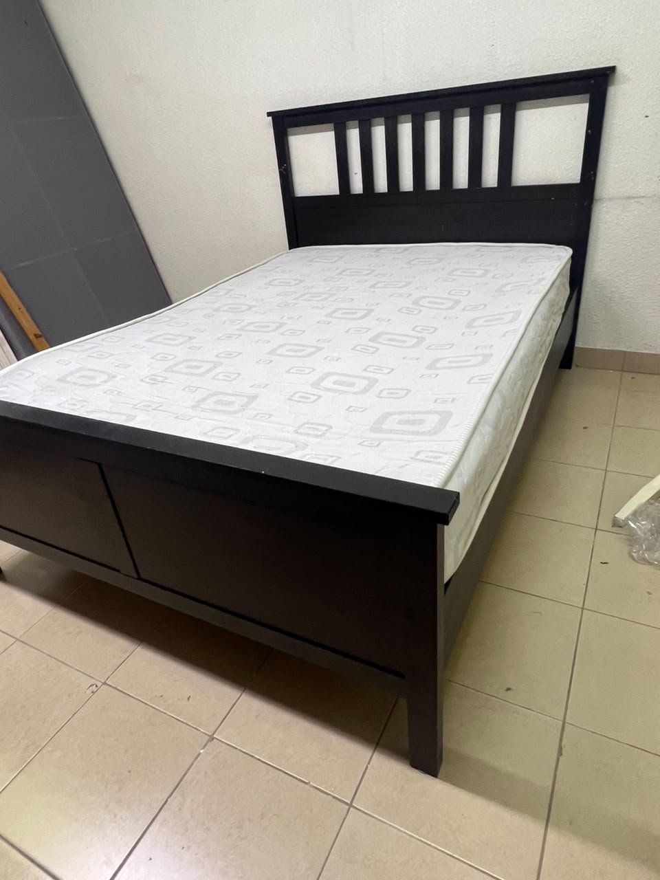 An IKEA "HEMNES" wooden bed frame in a black-brown finish, featuring a slatted headboard and a matching mattress. - Image 7