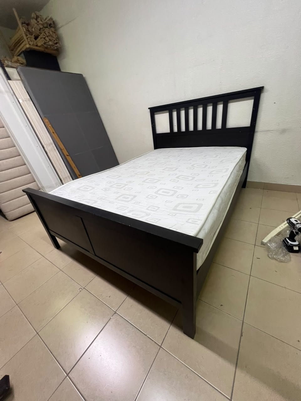An IKEA "HEMNES" wooden bed frame in a black-brown finish, featuring a slatted headboard and a matching mattress. - Image 8