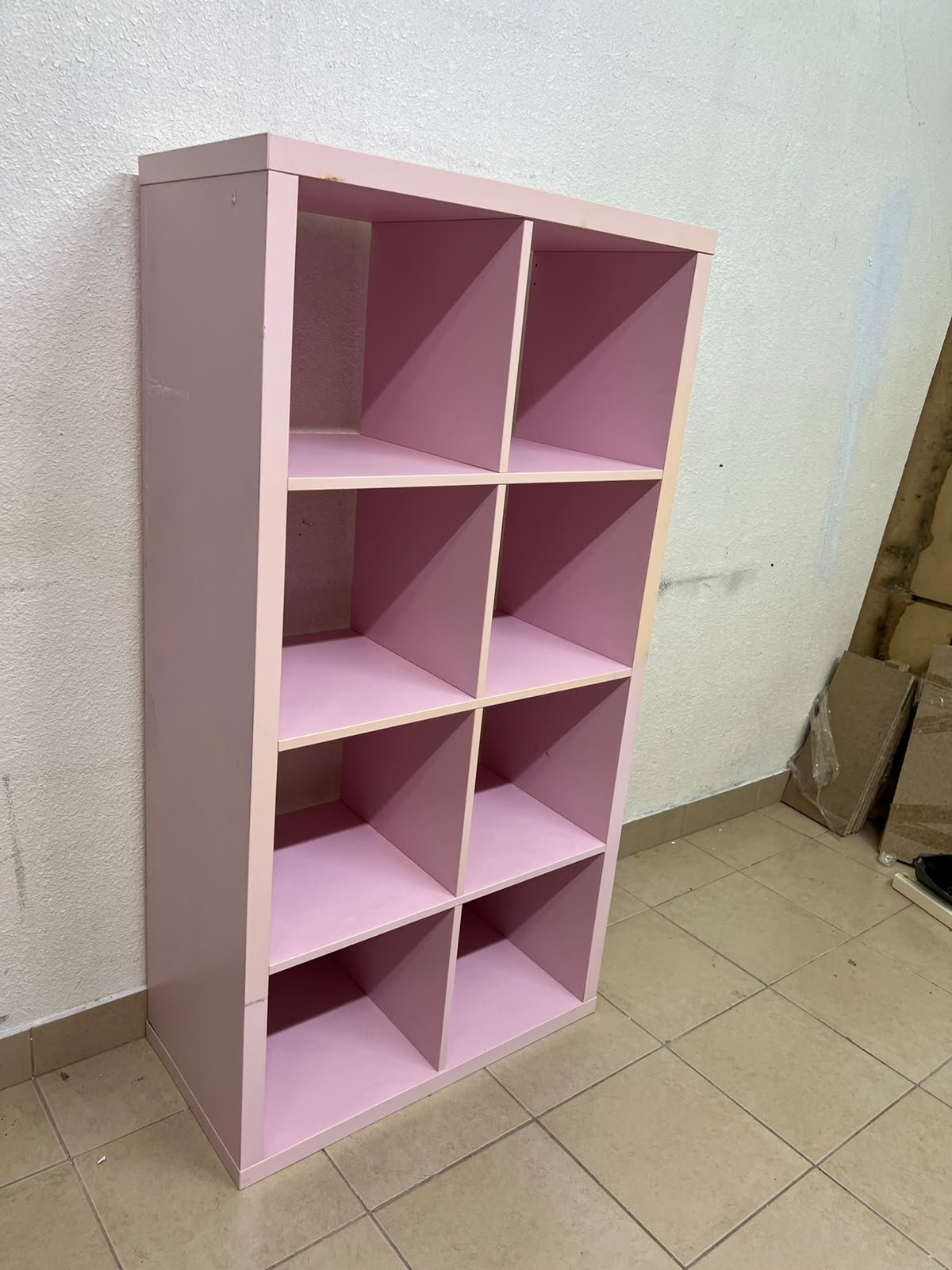 IKEA KALLAX shelving unit in pink, featuring a modular, 8-compartment cube design.